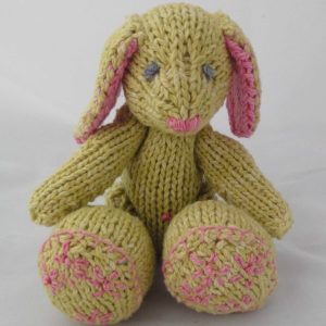 A jointed green knit bunny with pink embellishments