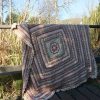 Thingie-ma-bob crochetAfghan/Blanket hanging over a railing in the shade of a tree