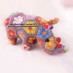 Crocheted rhinoceros soft toy made with colorful African flower motifs in hexagon and pentagon shapes; handcrafted using bright yarns in pink, red, orange, yellow, blue, and purple, forming a detailed 3D animal figure—pattern by Heidi Bears Designs.