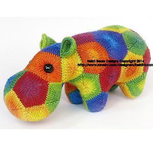 Colourful hand-knitted hippo toy made from knitted, modular motives. Features a soft, cosy finish with bright rainbow hues and button eyes. Designed by Heidi Bears.