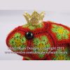 Close up of a crocheted frog prince toy made with red and green African flower motifs, featuring a golden crown and black button eyes; handcrafted using hexagons and pentagons pattern by Heidi Bears Designs.