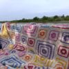 The Namaqua Blanket draped over the side of a boat with calm water and reeds behind