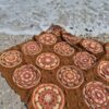 A wave washing up to the top edge of the Over the Coral Sea crochet blanket by Hooked on Sunshine, with coral, cream and green mandala motifs in warm caramel brown ColourSpun Pure Cotton DK.